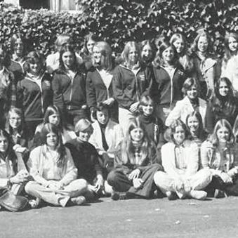 A large group of people pose together outdoors in a black-and-white photograph.