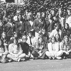 A large group of people pose together outdoors in a black-and-white photograph.