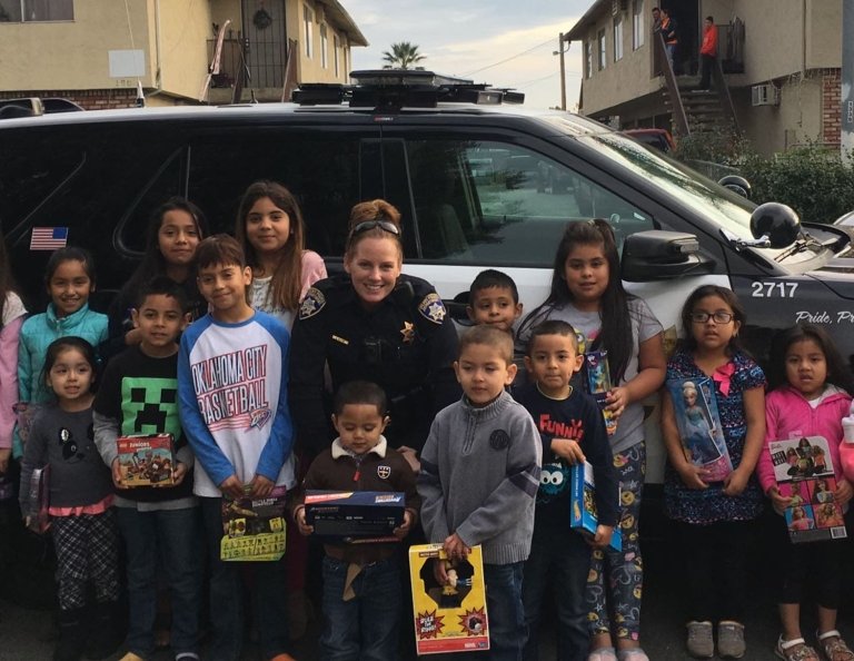 Children from Gilroy, California, surround the Gilroy Police Department’s Dawn Delfino on Christmas Eve 2017. Delfino was named sergeant Nov. 1, 2020. (Photo courtesy Dawn Delfino.)